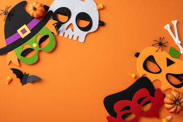 Halloween-themed flat lay featuring colorful masks and vibrant decorations arranged on an orange...