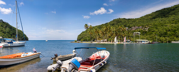 Dreams: Boats Bobbing in Marigot Bay, Saint Lucia's Tropical Embrace
Tranquil Marigot Bay, Saint Lucia, where colorful boats gently rest on calm, blue waters amidst lush green hills and swaying palm