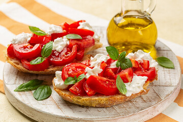 Bruschetta with creamy burrata cheese, fresh tomatoes and basil. Italian summer appetizer. Close up.