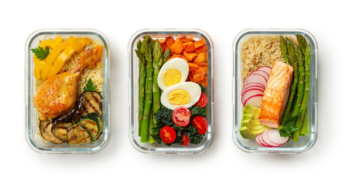 Healthy meal prep ideas, containers, lunchboxes with variety of high protein trendy food, salmon quinoa and avocado, eggs asparagus, kale, sweet potato, chicken, barley and zucchini. White background.