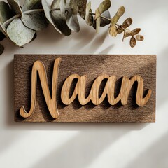 Wooden sign with the word "Naan" and decorative leaves above it.