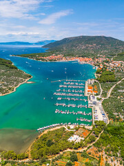 Drone shot capturing the marina and town of Cres, surrounded by mountains and crystal-clear...