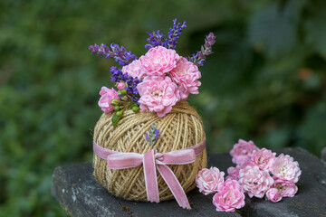 romantische Dekoration mit Rosenblüten, Lavendel und Salbei im Garnknäuel	

