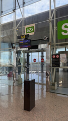 Modern Airport Boarding Gate S23 at Barcelona Airport with Flight Information Display and Glass...