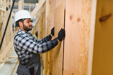 Indian carpenter works on the construction of modular houses