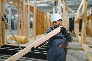 Construction of modular houses. Male indian construction worker in uniform and hard hat at construction site