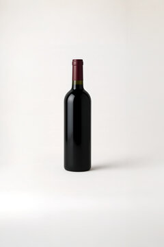 Red wine bottle mockup with blank label space, isolated on white background, ideal for branding design, label presentation, or packaging mockup for alcoholic beverage products

