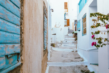 Charming narrow street with stone pavement in Plaka, Milos, Greece