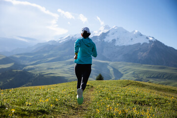 Trail runner running on the high altitude grassland mountain top trail © lzf