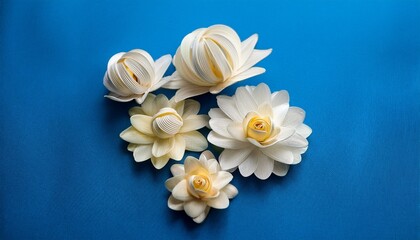 Obraz premium delicate cornice flowers made of twisted glicine in shades of white and cream on a bright blue background