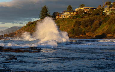Big wave splash on the rocky platform shore.