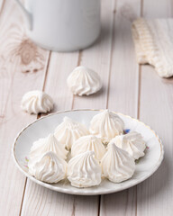 Fresh homemade meringue cookies over wooden table
