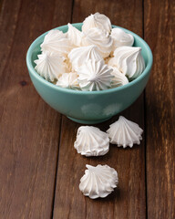 Fresh homemade meringue cookies over wooden table