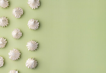 Fresh homemade meringue cookies over green background with copy space