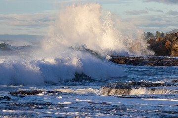 Big wave breaking on the rocky shore.