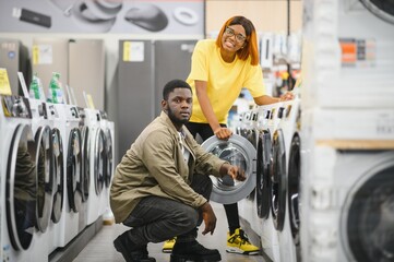 African American Couple choosing washing machine at electronics store