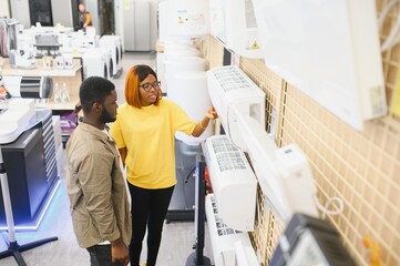 An African American man and woman choose an air conditioner in an electronics store