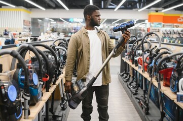 New vacuum cleaner. An African man buys a vacuum cleaner in a household goods store