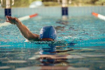 Woman swimming with swimming hat and swimsuit in swimming pool