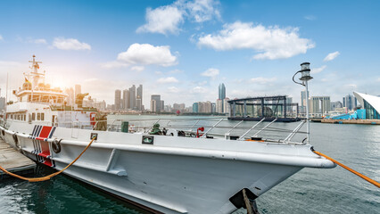 Coast guard ship docked in harbor with city skyline in background