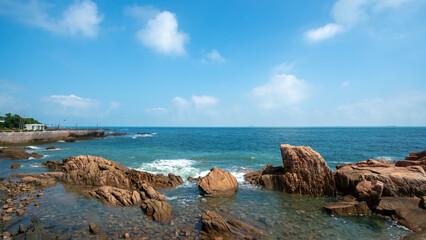 Scenic coastal view with clear blue sky and rocky shoreline