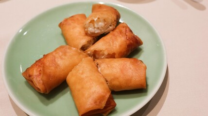 close up of Cantonese Hong Kong style teahouse (yum cha) dim sum- deep fried spring roll stuffed with prawns and pork filling, copy space on the right