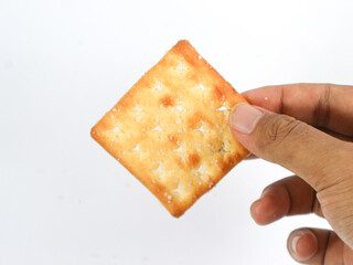 isolated hand holding a square sweet cracker with sprinkled sugar on top on a white background