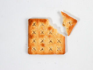 isolated sweet square cracker with sprinkled sugar on top which is broken in several parts on a white background