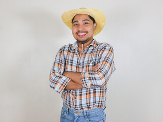 Asian male farmer wearing a rattan hat folding his hands while smiling