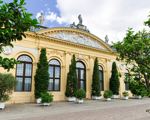 Baroque-style palace building with statues and trees under a clear blue sky in Kassel, Germany
