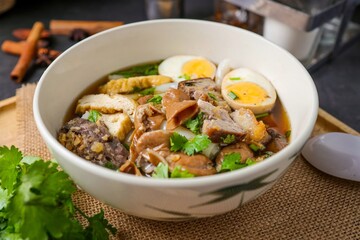 Chinese rolled noodles with crispy pork and egg in black soup,Rolled Rice Noodles in Five-spices Broth , Chinese noodles, thai called kuay jap
