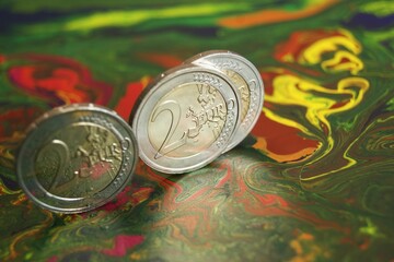 Proof 2 euro coins on a mottled abstract surface.