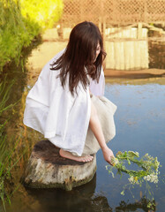 On Ivan Kupala, a girl makes a wish and throws a wreath into the river. Celebration of Ivan Kupala in Donbass July 2025