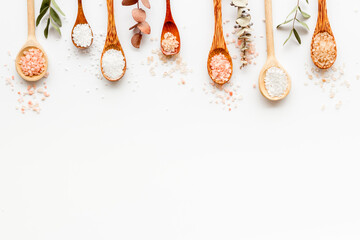 Spa treatment body care cosmetics - sea salt and scrubs in spoons, top view