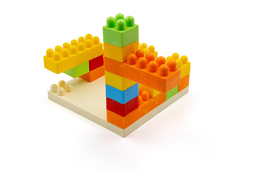 Colorful plastic building blocks assembled into a structure on white background