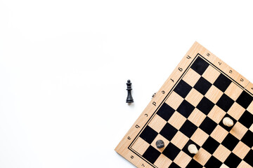 King chess piece lying down near chessboard after checkmate during the game, top view