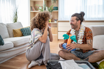 Couple getting ready for summer vacation, having fun with inflatable toys