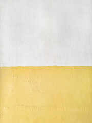 Background of the wall is painted with a horizontal line separating two different colors, yellow and white. Surface texture of yellow and white walls is uneven. The wall is painted using wall oil pain