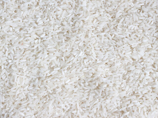 dry uncooked white rice background - top view, flat lay. scattered raw long grain rice. asian cuisine and culture. healthy eating ingredients. diet food