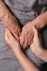Young woman holding senior woman hands. The granddaughter comforts the grandmother, the patient. Concept of support and care,  love, warmth, Mother's day, help.