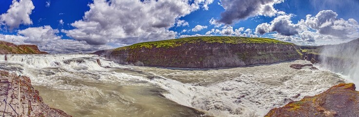 Panoramic view of Gullfoss waterfall Iceland with cliffs and green landscape
