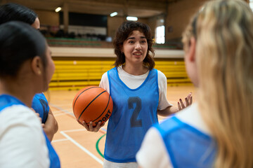 Female basketball player explaining game strategy to teammates