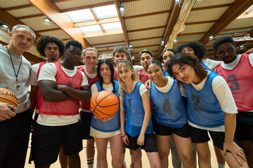 High school basketball team posing with coach and ball