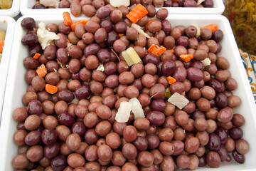 Freshly harvested olives with colorful vegetables displayed in a market for culinary enthusiasts...