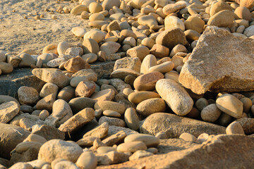abstract pattern of sunlit, multi-sized stones and rounded boulders