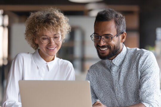 Smiling colleagues or company professionals using laptop to discuss online AI project together during workplace meeting, seated in office working environment with team support