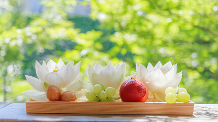 White lotus flowers and seasonal fruits arranged elegantly on a wooden tray, surrounded by soft sunlight.