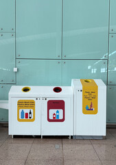 Barcelona, Spain - March 31, 2025: Recycling bins for plastic, metal, and glass waste in modern...