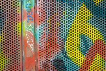 Farbenfrohe Graffiti an Eisentüre mit Lochblech am Rettungstunnel Heslacher Wasserfälle bei Stuttgart