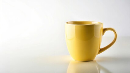 A vibrant yellow ceramic mug, perfect for morning coffee or evening tea, sits on a bright reflective surface against a clean white background.